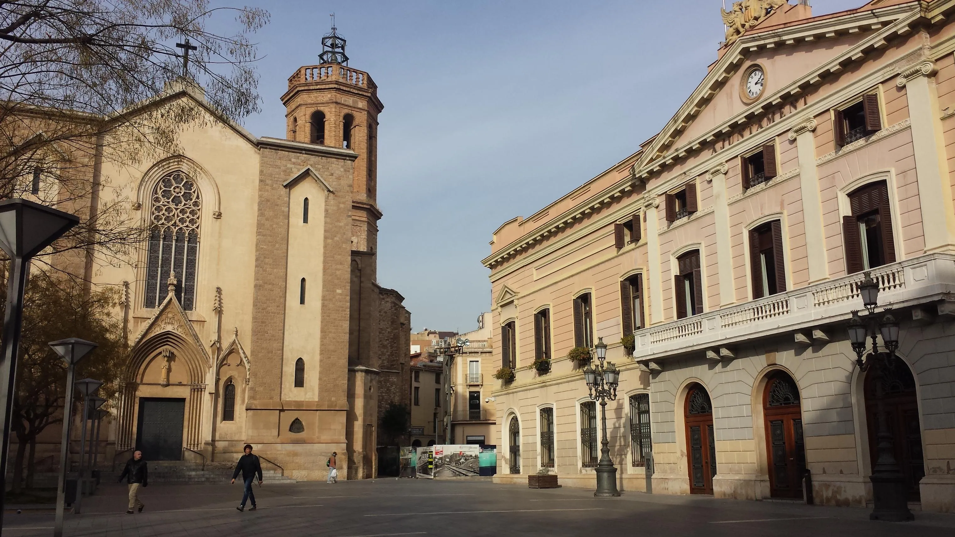 La plaça de Sant Roc de Sabadell, con la iglesia de Sant Fèlix a la izquierda y la fachada del Ayuntamiento, con el rótulo «Ajuntament», a la derecha.
