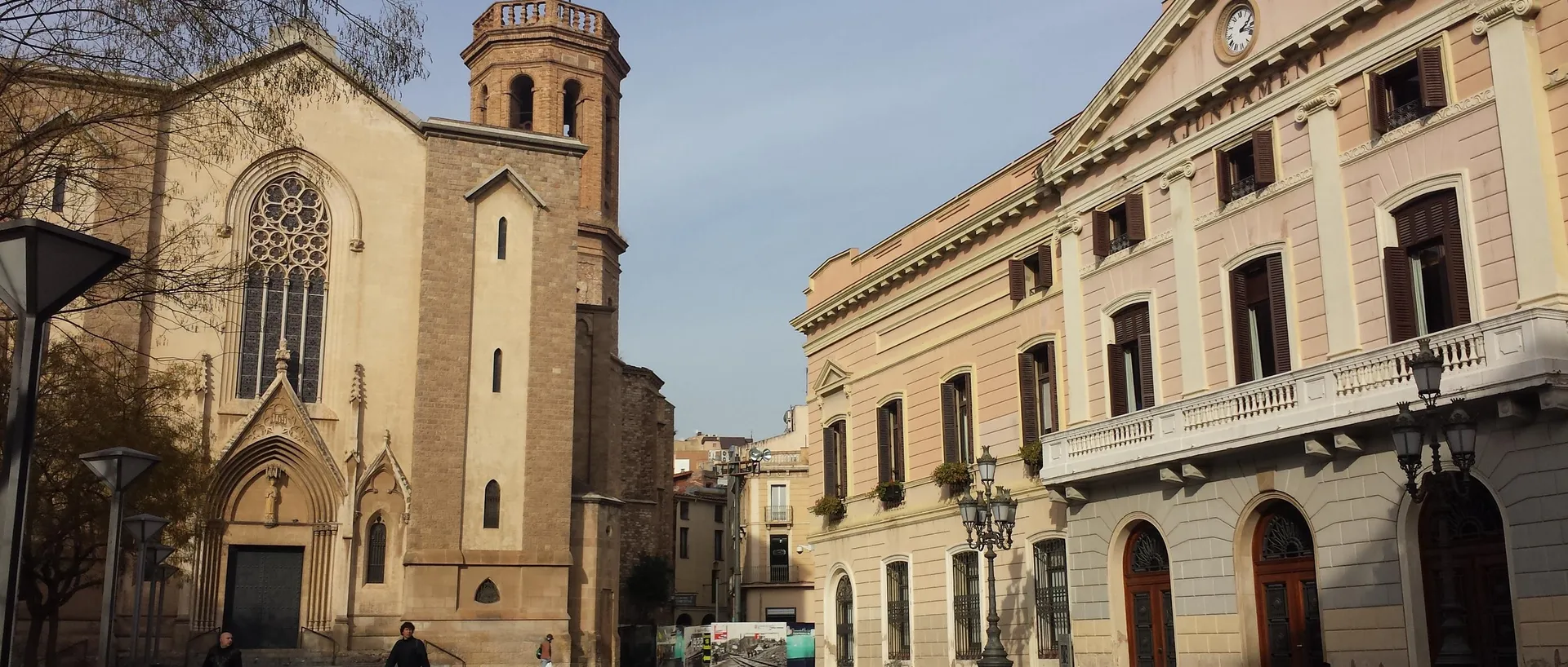 La plaça de Sant Roc de Sabadell, con la iglesia de Sant Fèlix a la izquierda y la fachada del Ayuntamiento, con el rótulo «Ajuntament», a la derecha.